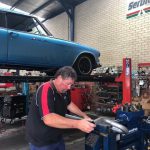 Man repairing exhaust — Vehicle Repairs in Tanilba Bay, NSW